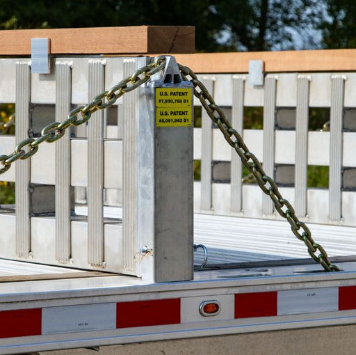 Right-side aluminum load leveler stake measuring 4-1/8 inches long, 4-1/8 inches wide, and 18-1/4 inches high; weighs 10 lbs and fits 3/8-inch chain for securing step deck trailer ramps.